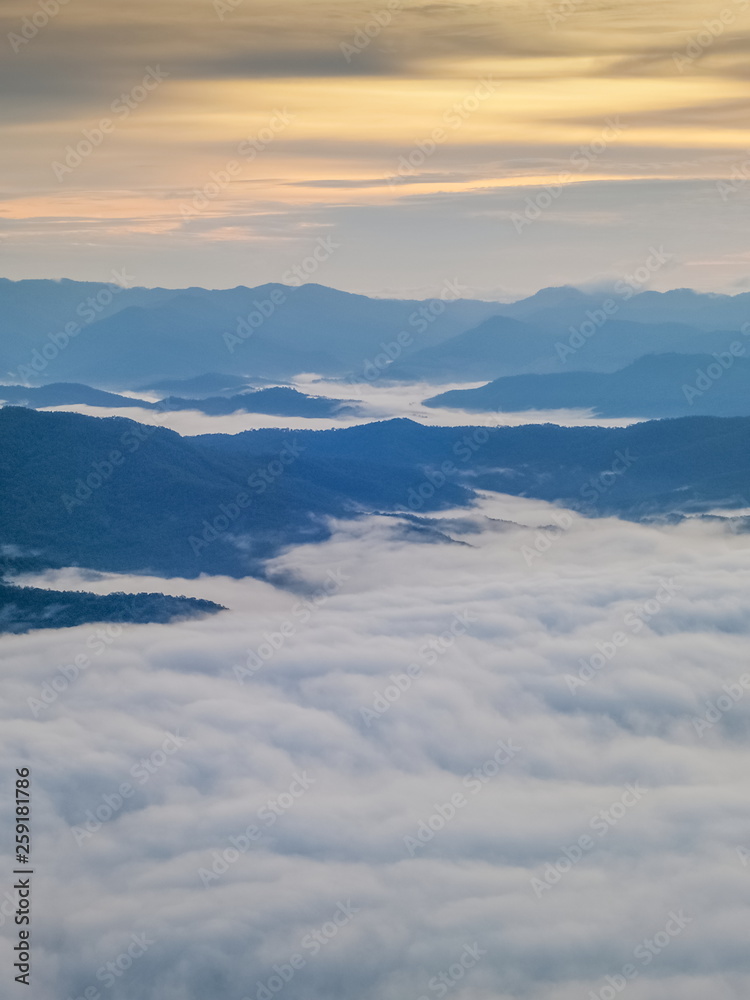 Mountain view morning of the hills around with sea of mist and soft yellow sun light in the sky background, sunrise at Doi Samur Dao, Sri Nan National Park, Nan, Thailand.