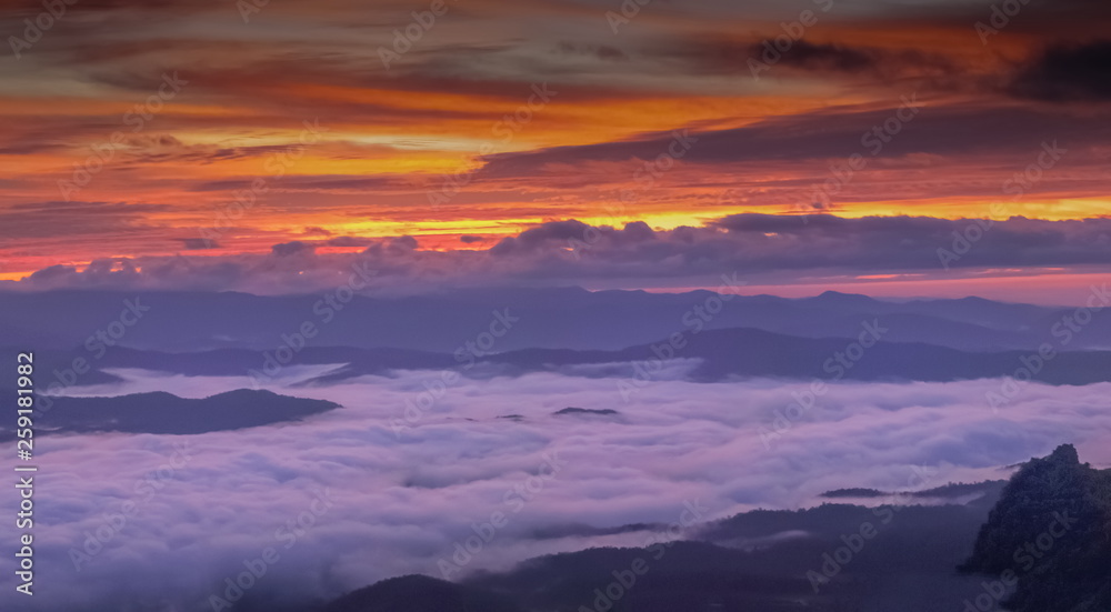 Mountain view morning of the hills around with sea of mist and colorful red sun light in the sky background, twilight at Doi Samur Dao, Sri Nan National Park, Nan, Thailand.