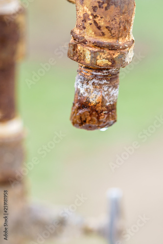 Fototapeta Naklejka Na Ścianę i Meble -  Old rusty tap with a drop of water. Macro shot