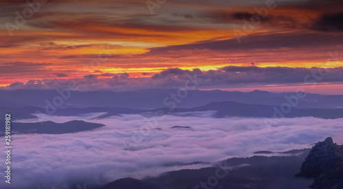 Mountain view morning of the hills around with sea of mist and colorful red sun light in the sky background  twilight at Doi Samur Dao  Sri Nan National Park  Nan  Thailand.