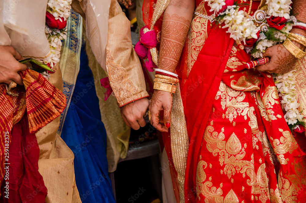 Indian wedding rituals, Gruha Pravesh / Gruhapravesh / Griha Pravesh, closeup picture of right feet of a Newly married Indian Hindu bride dipping her fit in a plate filled with liquid kumkum then step