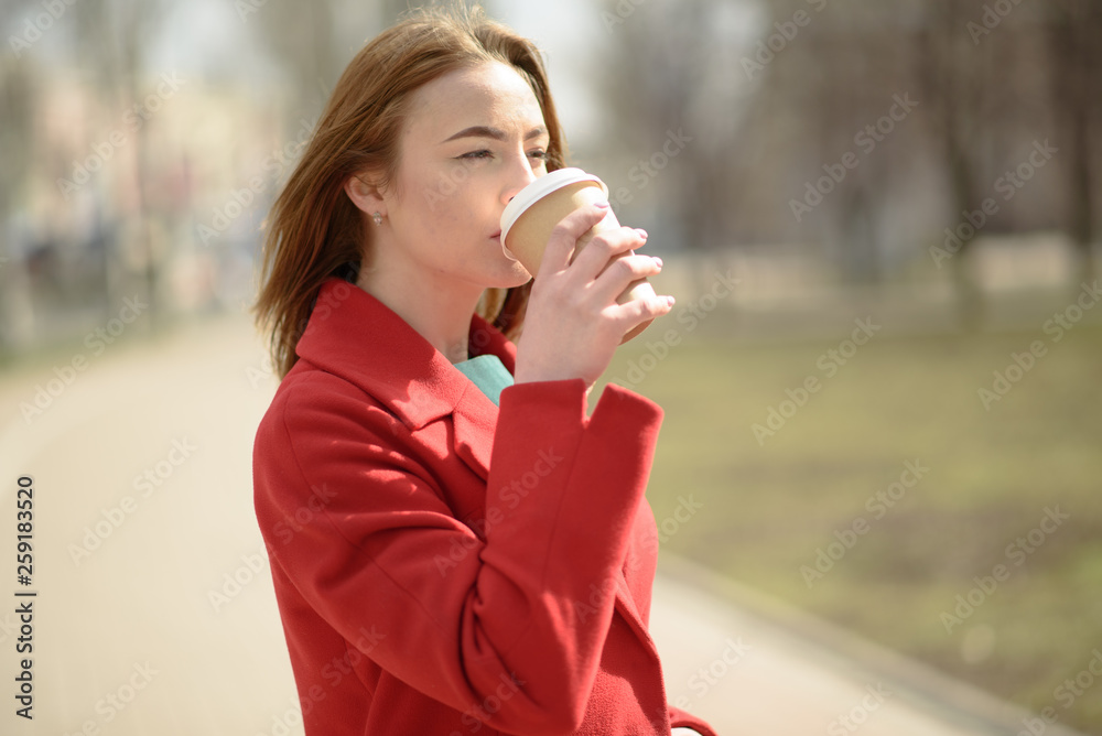 Happy girl floats with coffee down the street Happy girl floats with coffee down the street