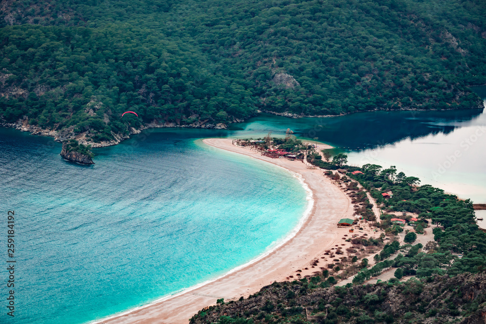 Paraglider flying on Oludeniz beach in Fethiye, Mugla, Travel destination. Summer and holiday concept. Lycian way. Panoramic view.