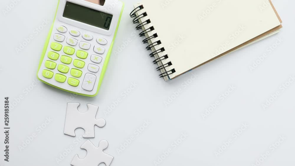 Calculator and notebook and puzzle, view from above Calculator and notebook and puzzle, view from above