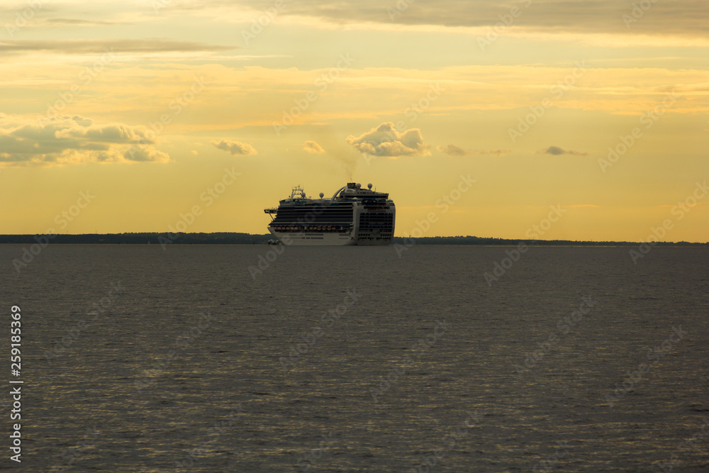 Cruise ship in the Gulf of Finland on a background of golden sky