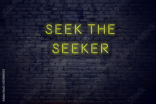 Positive inspiring quote on neon sign against brick wall seek the seeker photo