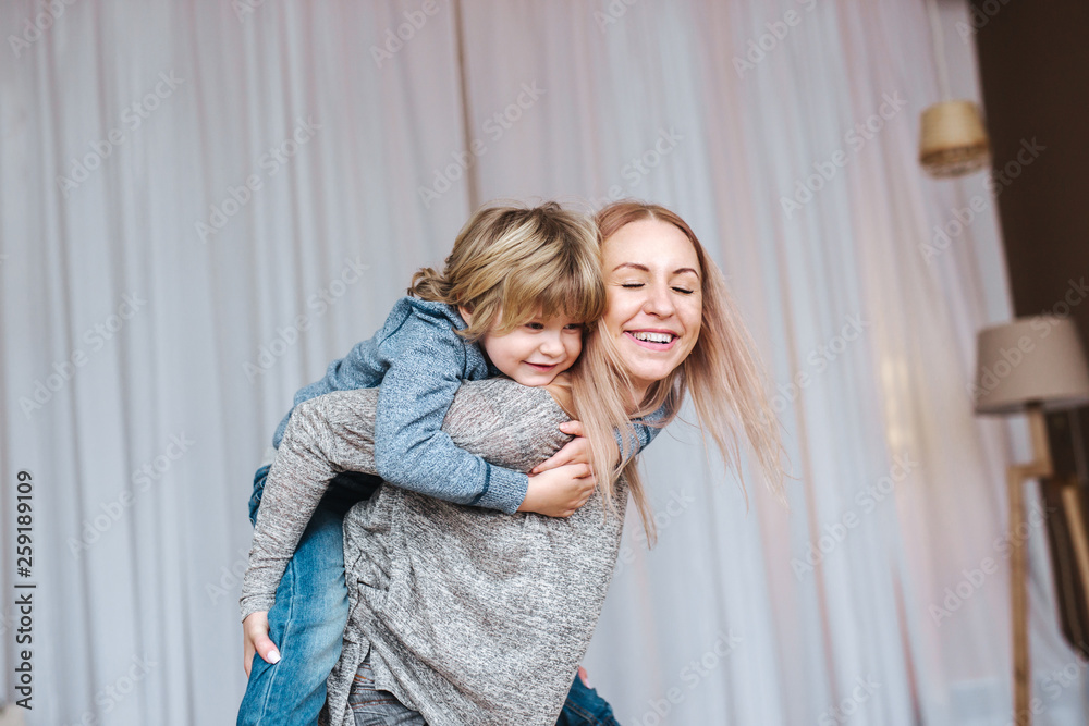 Mother carrying son on shoulders at home Mother carrying son on shoulders at home