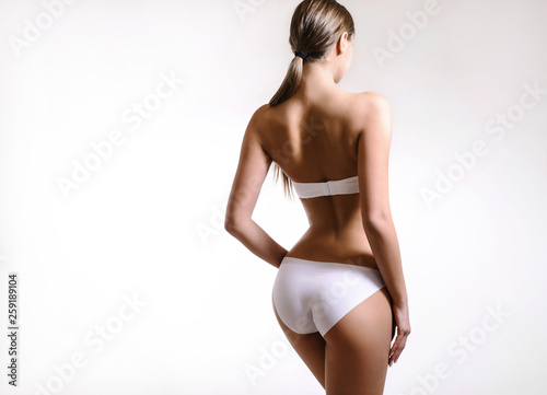 Beauty perfect slim body: fit and sporty girl in underwear. Beautiful and healthy woman posing at white background. Sport, wellness, fitness, diet, weight loss and healthcare concept.