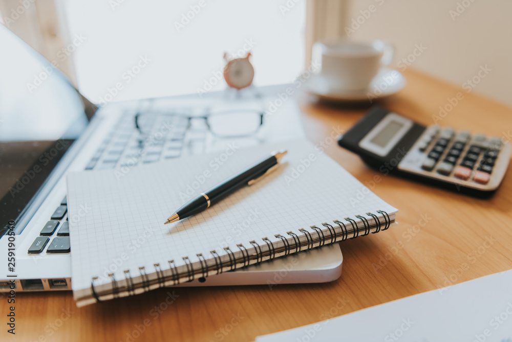 Laptop with financial documents on wooden table