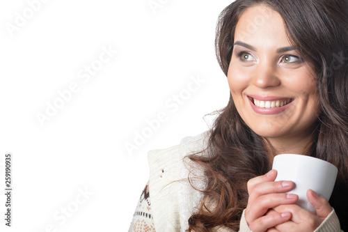 Beautiful curly woman wearing warm clothing holding cup isolated on white