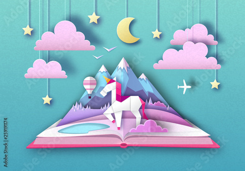 Open fairy tale book with unicorn and mountain landscape. Cut out paper art style design