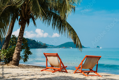 Fototapeta Naklejka Na Ścianę i Meble -  Luxury beach resort, beach loungers near the sea with white sand over sea Topical island background, summer vacation concept, holiday and tourism design. Exotic landscape, inspirational leisure banner