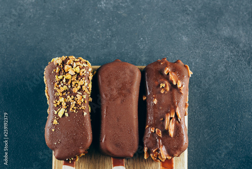 Eskimo ice cream in chocolate glaze on blue background. Yummy sweet food snack treat. Top view, copy space photo