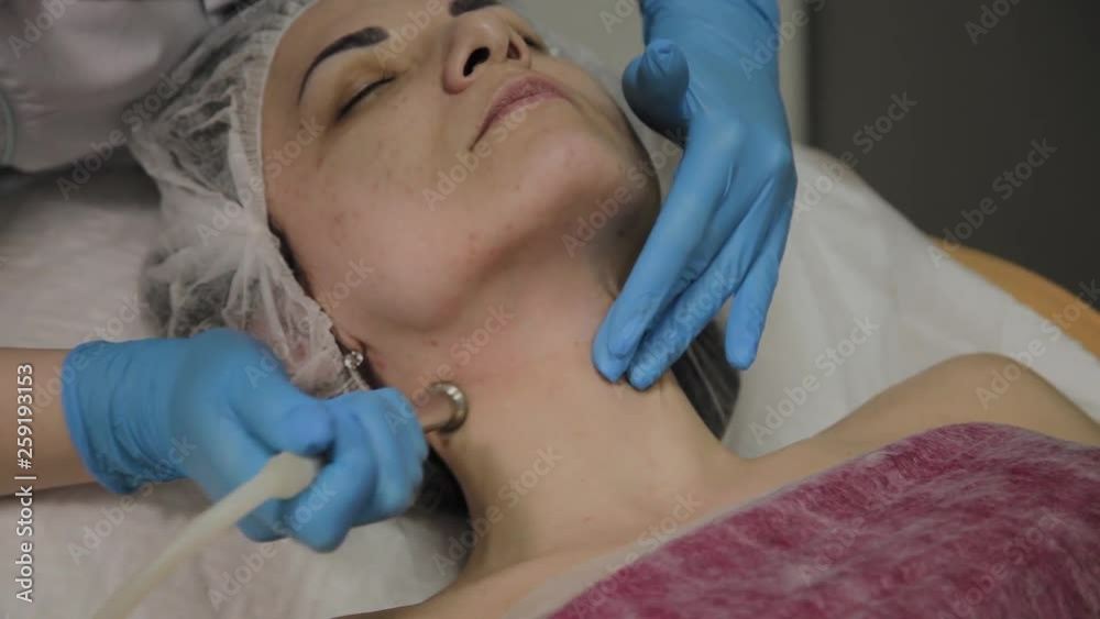 A professional cosmetologist makes a woman vacuum cleaning the face in a beauty salon. Cosmetological innovations. A professional cosmetologist makes a woman vacuum cleaning the face in a beauty salon. Cosmetological innovations.