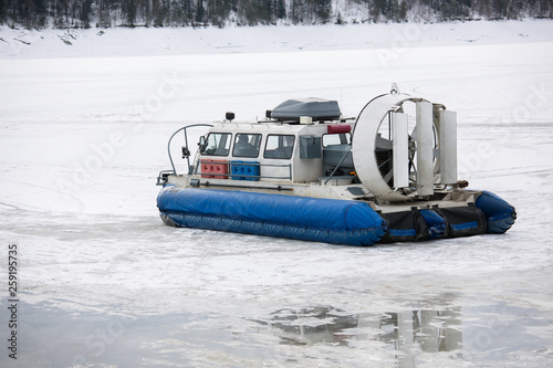 Hovercraft transporter on the ice of river in winter day