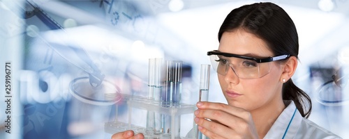 Young female scientist standing  on background