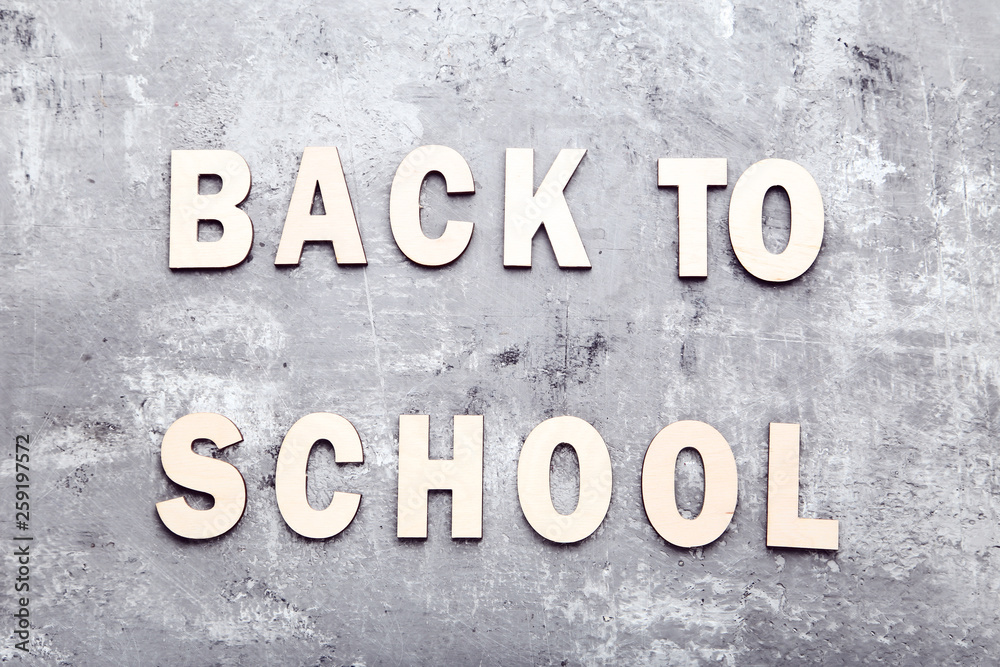 Inscription Back To School on grey wooden table Inscription Back To School on grey wooden table