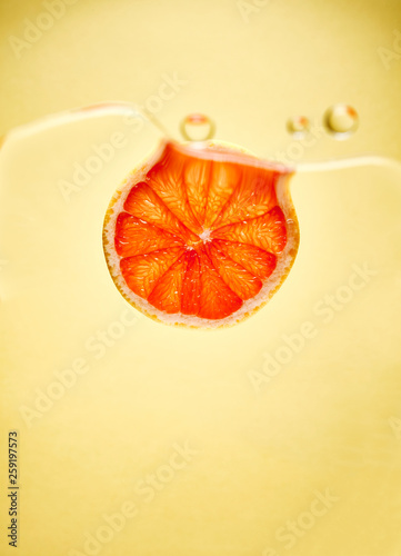 Fruit slice in water against yellow background