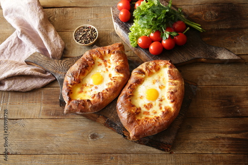 Two Khachapuri Adjara traditional Georgian dishes. Baked bread stuffed with cheese and eggs. With copy space for text. Flat lay. Top view. 