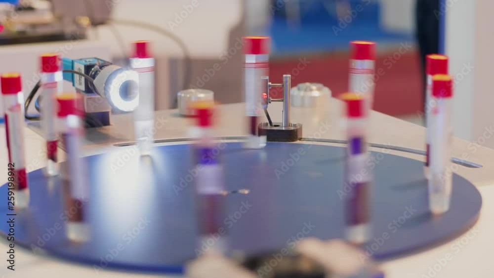 Automatic test set and laser scanning test tubes on speed pipette carousel stand in laboratory. Computer-aided quality system with scanner controlling bar code and names of glass-tubes. Scanning unit Automatic test set and laser scanning test tubes on speed pipette carousel stand in laboratory. Computer-aided quality system with scanner controlling bar code and names of glass-tubes. Scanning unit