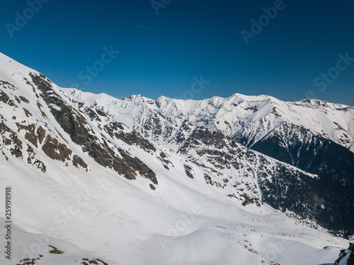 winter landscape with the mountain peaks covered by snow and clouds. aerial view by drone. romanian mountains  Negoiu peak  Fagaras Mountains