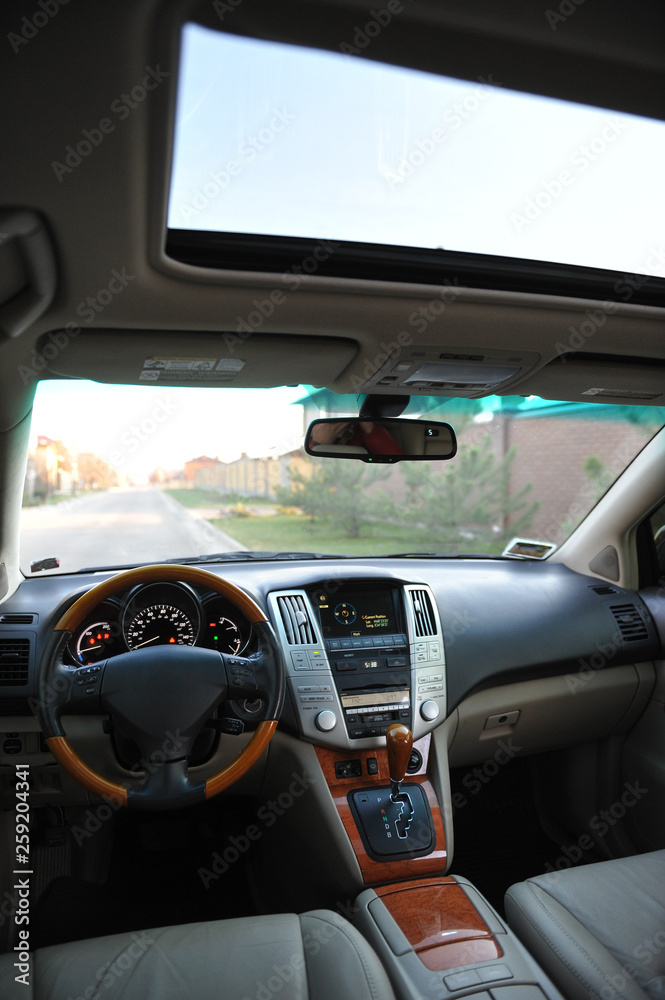 Fototapeta premium Modern luxury prestige car interior, dashboard, steering wheel. Perforated leather, wooden interior.
