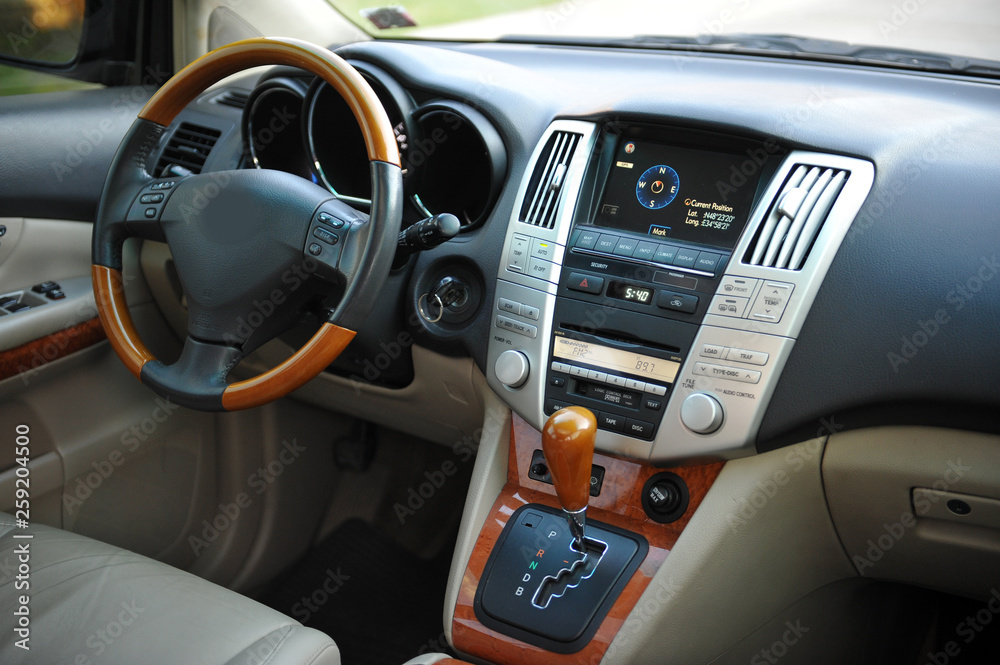 Modern luxury prestige car interior, dashboard, steering wheel. Perforated leather, wooden interior.