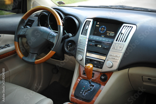 Modern luxury prestige car interior, dashboard, steering wheel. Perforated leather, wooden interior. © ruslan_shramko