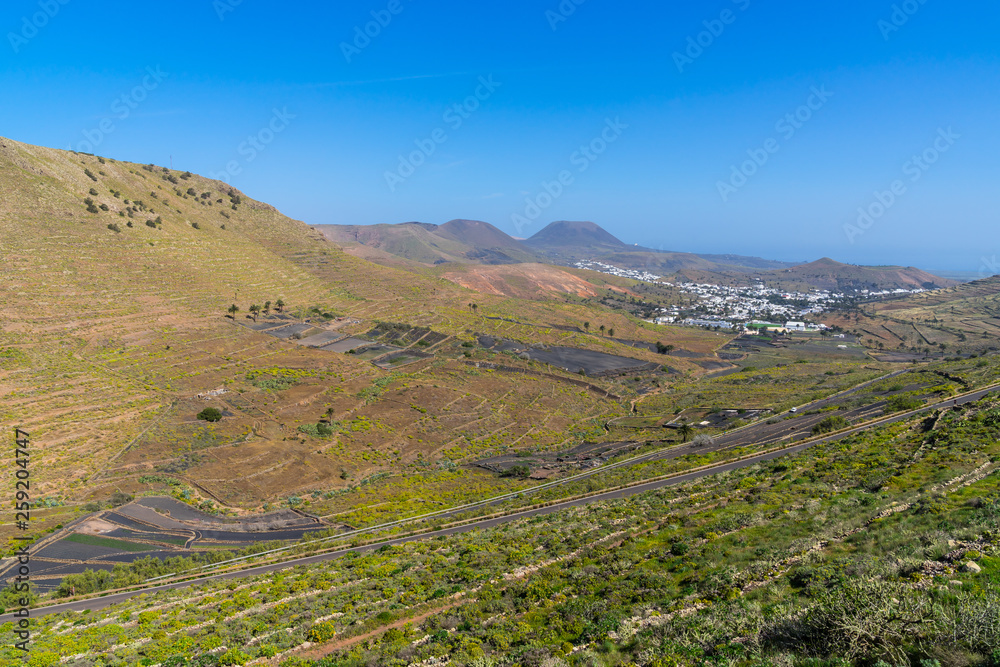 Spain, Lanzarote, Rural arid countryside in vale of palm city haria next to volcano mountains
