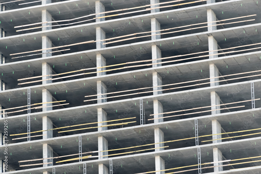 wall with window openings in a multi-storey high-rise residential building under construction from concrete and brick