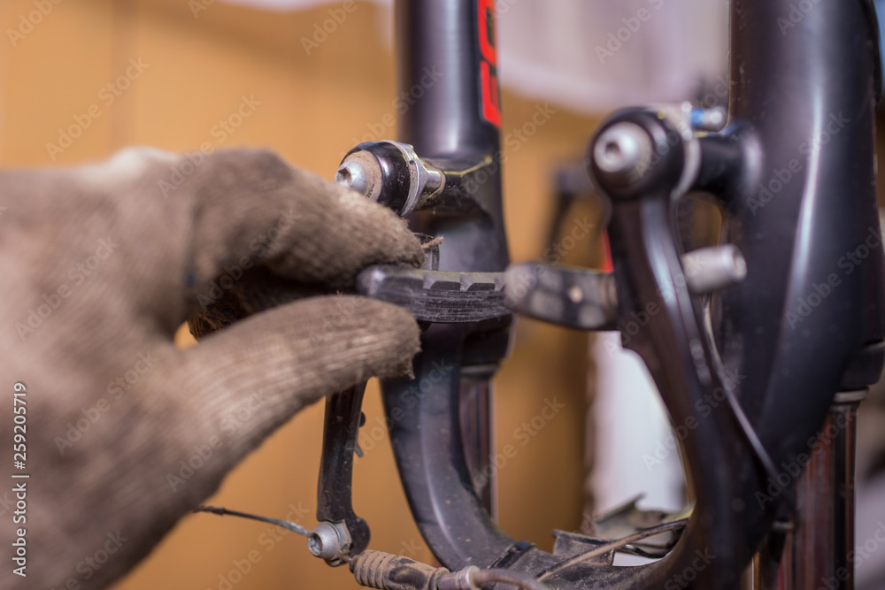worn brake pads. male mechanic making service in bicycle repair shop, repairman fixinig bike brakes using special tool worn brake pads. male mechanic making service in bicycle repair shop, repairman fixinig bike brakes using special tool