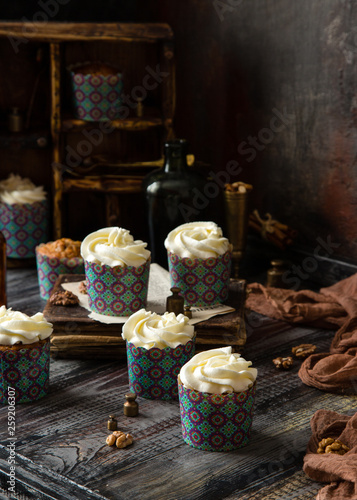Delicious homemade carrot cupcakes in blue paper cups with white beautiful icing 