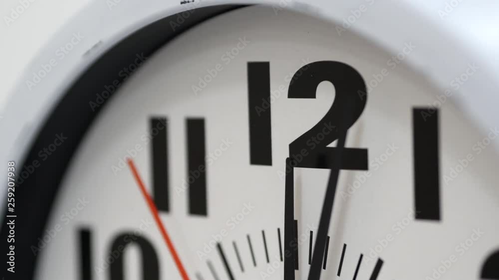 The Time On The Clock Twelve. Clock With The Red Arrow Running In The Background Of The Arabic Numerals. The Time On The Clock Twelve. Clock With The Red Arrow Running In The Background Of The Arabic Numerals.
