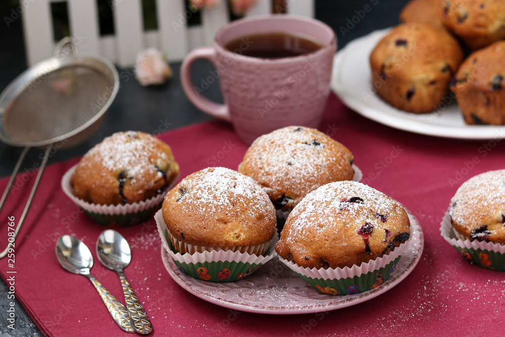 Black currant muffins in a plate on a pink background Black currant muffins in a plate on a pink background