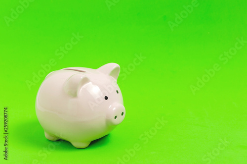 Pink piggy bank on green background. Money and business.