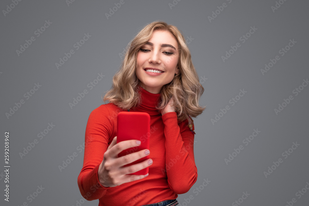 Smiling woman touching neck and taking selfie Smiling woman touching neck and taking selfie