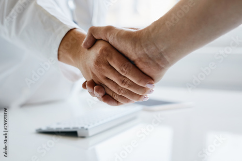 Female doctor shakes hands with his patient in the office