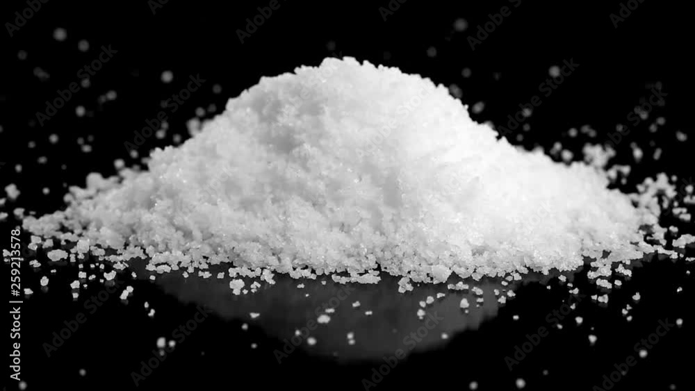 Heap of sea salt slowly rotating on black Heap of sea salt slowly rotating on black