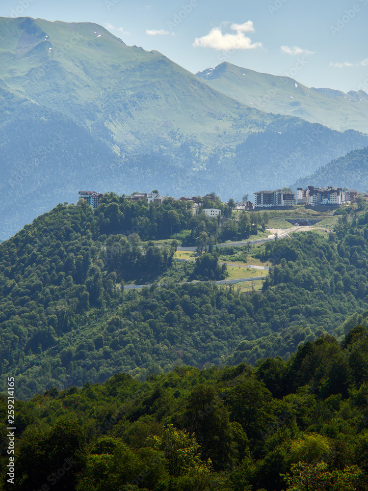 Fototapeta premium Hotel in the mountains among the green forest. Krasnaya Polyana, Sochi, Russia