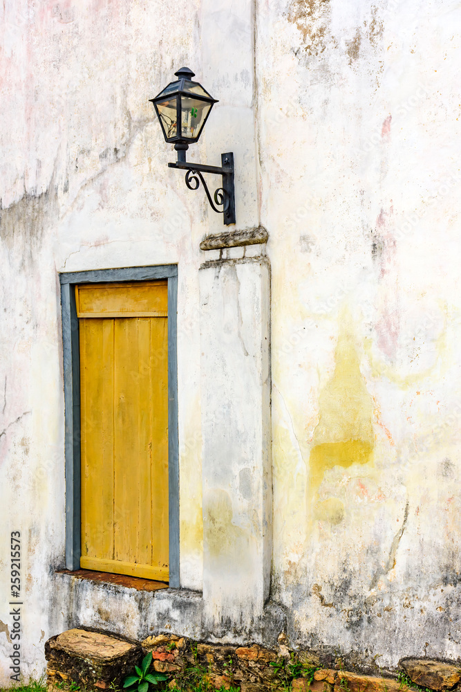Old residential lighting lantern next to a aged and anciente wooden window of an old colonial architecture building in the city of Ouro Preto in Minas Gerais Old residential lighting lantern next to a aged and anciente wooden window of an old colonial architecture building in the city of Ouro Preto in Minas Gerais