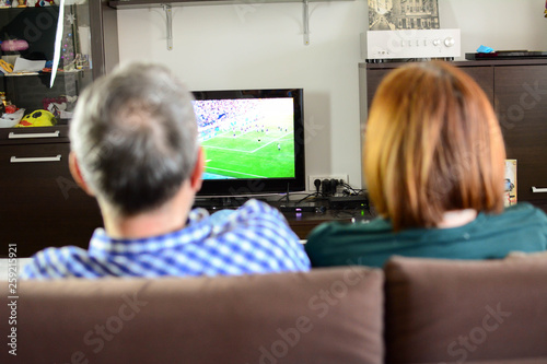 Mature couple watching television.