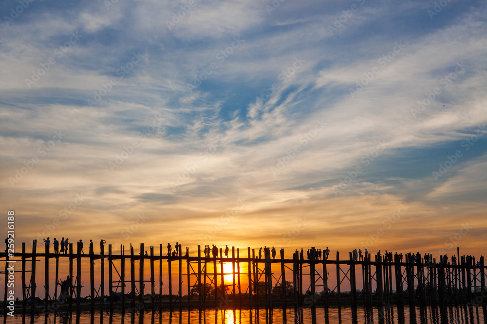Sunset over U Bein Wooden bridge with locals' and tourists' silhouettes, Mandalay, Myanmar Sunset over U Bein Wooden bridge with locals' and tourists' silhouettes, Mandalay, Myanmar
