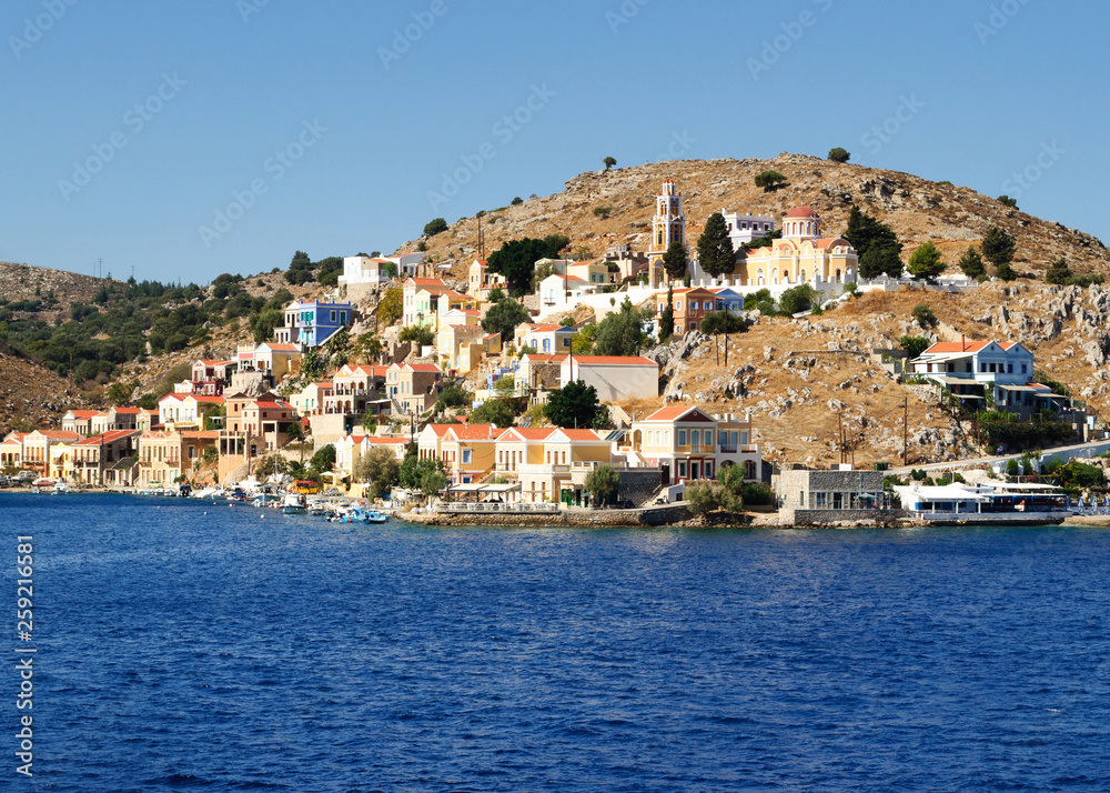 Colorful architecture of the buildings of the rocky shore of the island Symi.