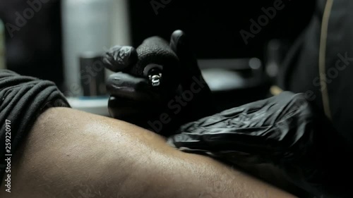 Tattoo artist makes a tattoo on a man's hand
