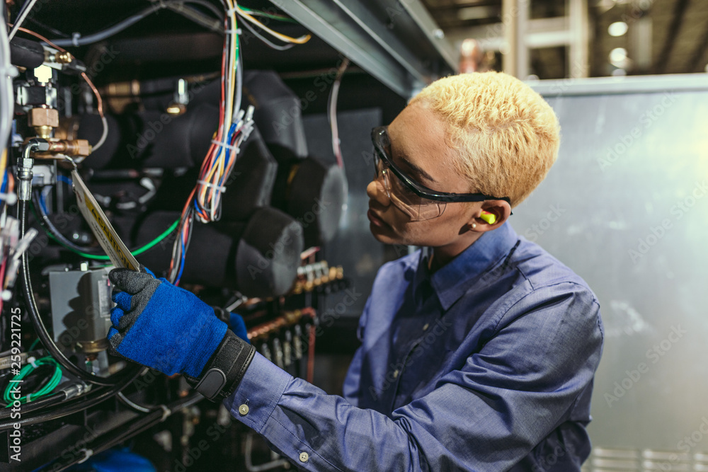Service technician inspecting equipment Service technician inspecting equipment