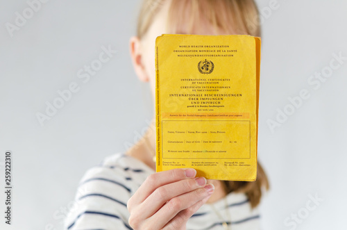 Foto Impfbereitschaft / Impfpflicht bei Kindern - Junges Mädchen hält Impfpass in ihr