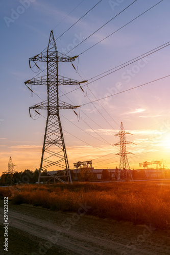 Supports high-voltage power lines against the blue sky. Electrical industry.