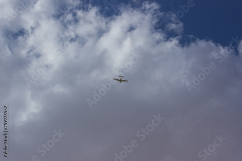 plane in sky from below on gray cloudy sky background flight transport in the air wallpaper pattern concept with empty copy space for text