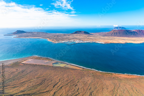 Unique panoramic magnificent aerial view of volcanic island La Graciosa, south cape, port Caleta del Sebo, and Salinas del Rio, Lanzarote, Canary Islands, Spain. Travel concept.