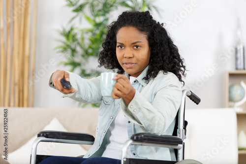 young woman in wheelchair drinking coffee indoors